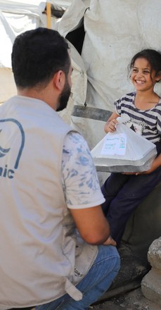 Gazze'de bir çocuğa yardım paketi ulaştırılıyor