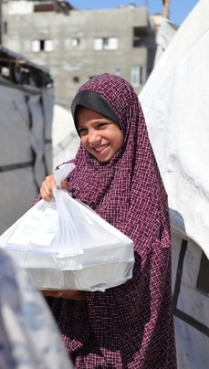 Gazze'de bir kız çocuğuna yardım paketi ulaştırılıyor